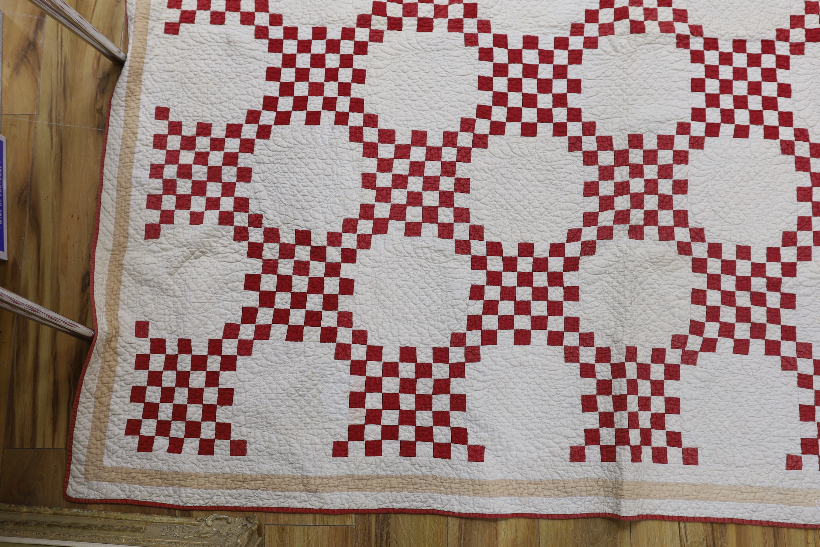 A 19th century Irish chain quilt with red and beige fabric on cream background American